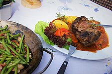 Zart geschmortes Lamm mit feiner Soße und Speckbohnen – traditionelle bayerische Küche im Landhotel Neuhof.