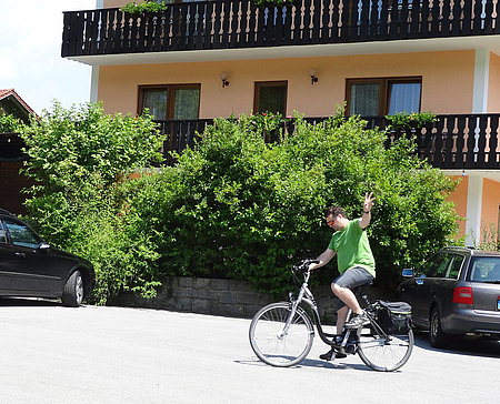 E-Bike-Urlauber planen eine Radtour im Bayerischen Wald auf einer Aussichtsbank nahe dem Landhotel Neuhof in Zenting.