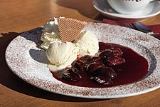 Warmer, hausgemachter Zwetschgenröster mit einer Kugel cremigem Vanilleeis als Seelenschmeichler nach dem Wandern.